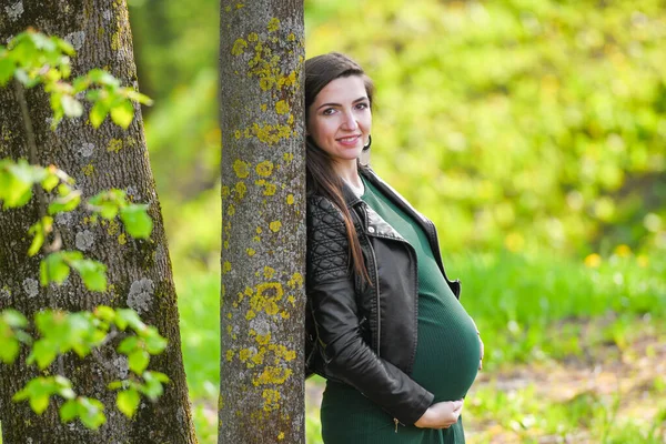 Schwangere Schülerin. attraktive schwangere Frau in Kleid Schulmädchen posiert auf der Straße. langhaarige schwangere Frau, die die Straße hinuntergeht, Schwangerschaft an der Universität — Stockfoto