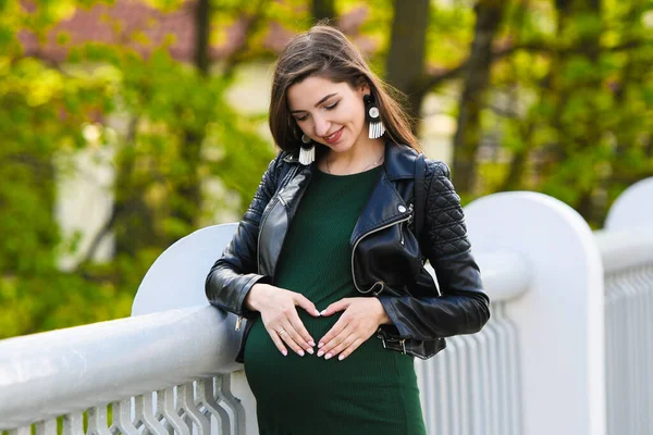 Fille enceinte sur le pont. Portrait d'une jeune femme enceinte heureuse sur un pont blanc. Reposez-vous et profiter de la nature — Photo