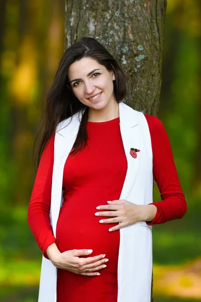 L'air frais est enceinte. Profiter de la nature. Jeune femme enceinte bras levés profitant de l'air frais dans la forêt verte . — Photo