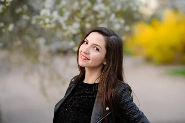 Morena posando en el jardín de otoño. joven hermosa morena sonriendo. al aire libre. árboles con hojas verdes. Jardín, parque. día soleado. follaje amarillo — Foto de Stock