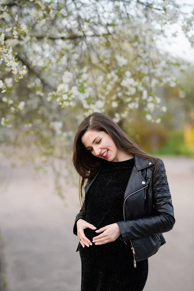 Ragazza incinta in giardino. Donna incinta si sente felice con la nuova vita a casa in giardino mentre prendersi cura del suo bambino. La giovane madre in attesa che tiene il bambino nella pancia incinta. Assistenza prenatale di maternità — Foto Stock