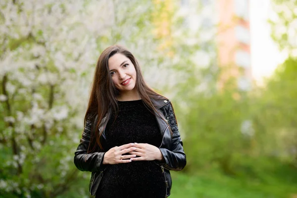 Une fille enceinte dans le jardin. Femme enceinte se sentant heureuse avec une nouvelle vie à la maison de jardin tout en prenant soin de son enfant. La jeune mère enceinte tenant le bébé dans le ventre enceinte. Soins prénatals de maternité — Photo