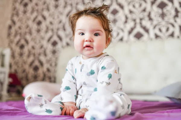 Getinte afbeelding van een vrolijke lachende jongen zittend op het bed. woninginrichting — Stockfoto