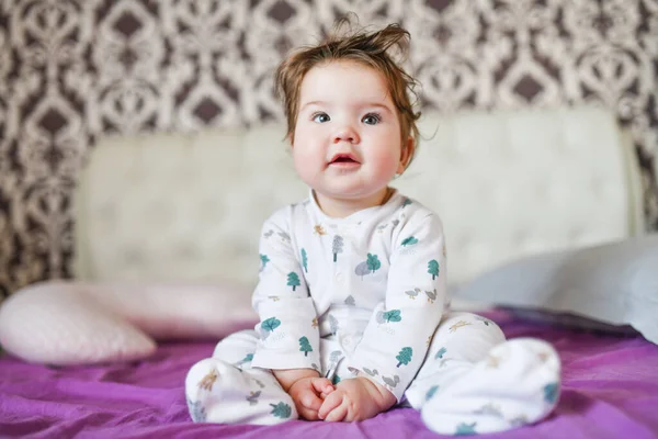 Getinte afbeelding van een vrolijke lachende jongen zittend op het bed. woninginrichting — Stockfoto