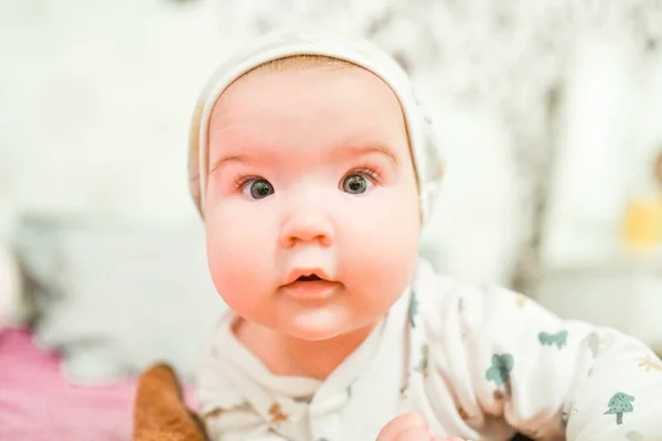 Een baby met een hoed thuis. Schattige baby in hoed op het bed plezier hebben — Stockfoto