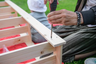 Kız tornavidayla vidayı çeviriyor. yakın plan