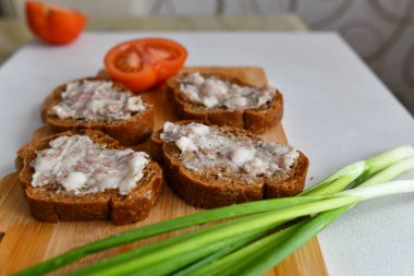 Ukrayna kahvaltısı. Tütsülenmiş domuz. Pastırma ve ekmek eski bir tahtada. Soğan ve domatesli..
