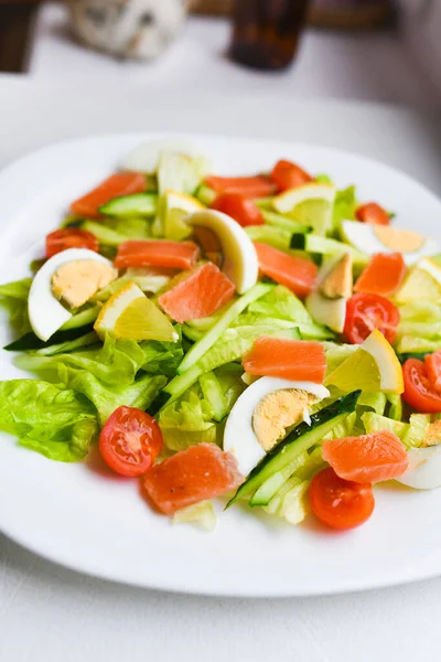 Insalata di verdure su un piatto bianco. Insalata fresca con uova, pomodori, spinaci e avocado su sfondo bianco vista dall'alto. Cibo sano . — Foto Stock