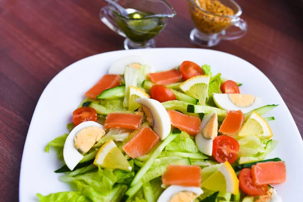 Insalata di verdure su un piatto bianco. Insalata fresca con uova, pomodori, spinaci e avocado su sfondo bianco vista dall'alto. Cibo sano . — Foto Stock
