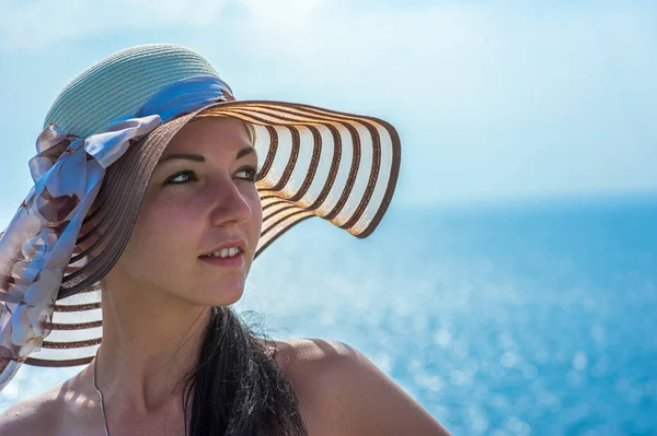 Primer plano de buen aspecto turista femenina disfruta de tiempo libre al aire libre cerca del océano en la playa, mira a la cámara durante el ocio en el día de verano soleado, posa para selfie. Feliz turista sonriente en los trópicos . — Foto de Stock