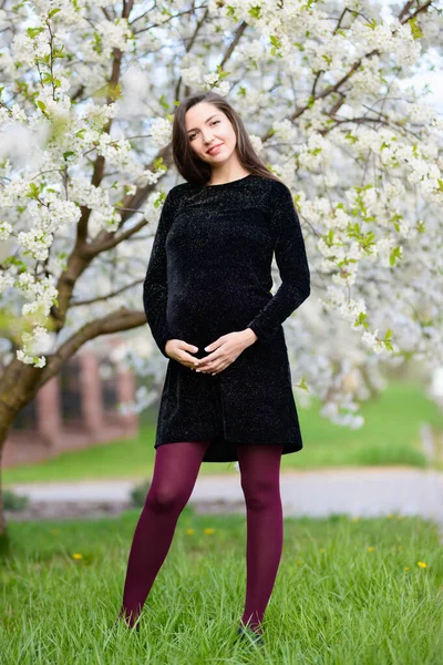 Yazın hamilelik. Güzel hamile kadın. Modaya uygun genç ebeveynler, çiçekler ve genç bir annenin mutluluğu. — Stok fotoğraf
