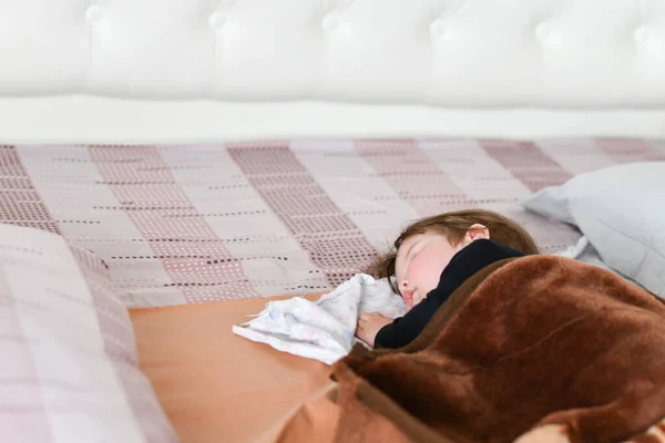 Babys tagsüber schlafen. gesunder Tagesschlaf für das Neugeborene. Das Kind schläft in einem orthopädischen Kinderkokon auf dem Bett. Kinderpause nach aktivem Spielen mit den Eltern — Stockfoto