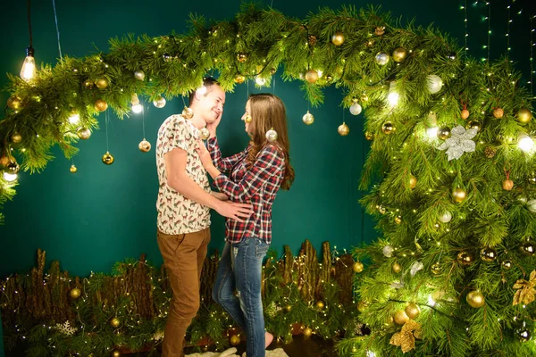 Pareja enamorada cerca de fondo navideño. Pareja joven besándose cerca del árbol de Navidad. Bajo perfil. Silueta —  Fotos de Stock