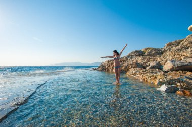 Denizden kızın üzerine sıçrıyor. Okyanus suyunda oynayan kadın