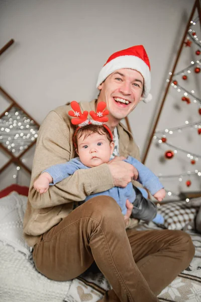 baby and father on christmas background. happy family father and child little daughter son and christmas miracle