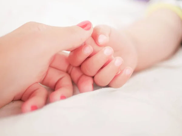 Mateřská ruka drží své dítě. Ruka novorozených dětí v matčině ruce. Máma a její dítě. Šťastný rodinný koncept. Krásný konceptuální obraz mateřství — Stock fotografie