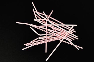 Siyah arka planda plastik borular. Rastgele dağılmış. Yazıt için bir yer. Yukarıdan görünüm