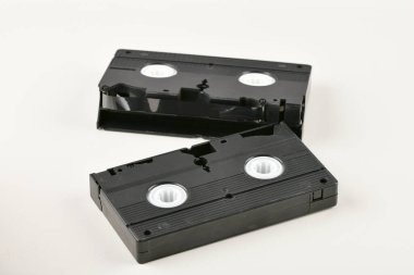 Beyaz arkaplandaki Retro nesneler. Düğmeye basılı telefon ve video kaset. Geçmişin analog medya teknolojisi. Boşluğu kopyala