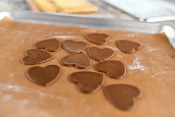 chocolate cookies in the form of heart, top view, pastry on the stove, dough preparation