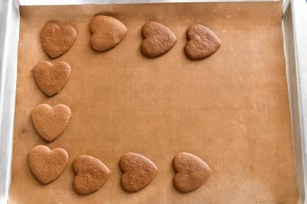 Chocolate cookies on a baking sheet, heart-shaped cookies cooked at home — Stock Photo, Image