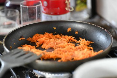 Kızartma için bir tavada soğan ile Rendelenmiş havuç