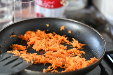 Kızartma için bir tavada soğan ile Rendelenmiş havuç