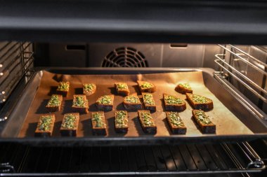 Fırında peynirli siyah ekmek. Peynirli ve baharatlı kızarmış ekmek, siyah tepside pişirilmiş, lezzetli bir kahvaltı..