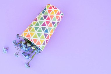 Mor arka planda bir bardakta çiçekler. Taze kesilmiş mor leylak çiçekleri. Renkli yemekler, çiçek açan çiçekler. Boşluğu kopyala