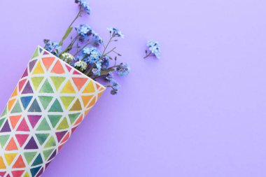 Mor arka planda bir bardakta çiçekler. Taze kesilmiş mor leylak çiçekleri. Renkli yemekler, çiçek açan çiçekler. Boşluğu kopyala