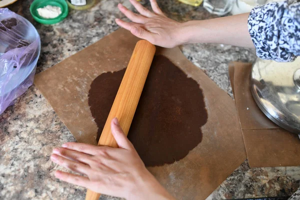 Annem hamuru sarar. Çikolata hamuru Ellerin hamuru hazırlama tarifi ekmeğiyle çalışıyor. Kadın eli pizza için hamur yapıyor. Kadının elleri hamuru yuvarlıyor. Annem hamuru mutfak tahtasına sarar. — Stok fotoğraf