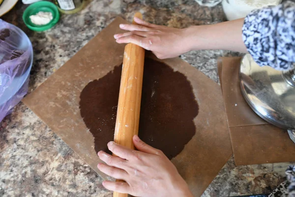 Annem hamuru sarar. Çikolata hamuru Ellerin hamuru hazırlama tarifi ekmeğiyle çalışıyor. Kadın eli pizza için hamur yapıyor. Kadının elleri hamuru yuvarlıyor. Annem hamuru mutfak tahtasına sarar. — Stok fotoğraf