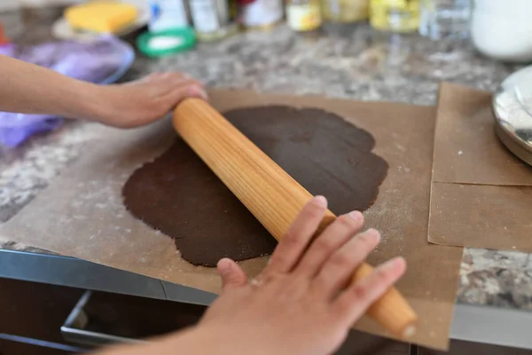 Annem hamuru sarar. Çikolata hamuru Ellerin hamuru hazırlama tarifi ekmeğiyle çalışıyor. Kadın eli pizza için hamur yapıyor. Kadının elleri hamuru yuvarlıyor. Annem hamuru mutfak tahtasına sarar. — Stok fotoğraf