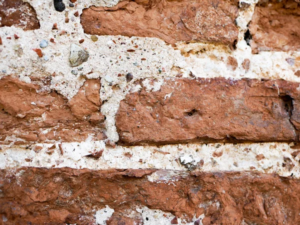 old brickwork. Fragment of an old wall with brickwork. Background. Uneven, obsolete, ancient, medieval, wallpaper, surface, chipped, weathered, masonry, rough