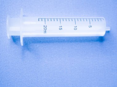 Mavi arka planda beyaz şırınga. Mavi arka planda şırınga. Mavi arka planda 5 ml şırınga. Deri altı ve kas içi enjeksiyonlar için tıbbi ekipman
