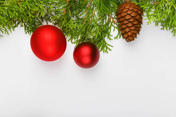 Bolas vermelhas em ramos verdes, fundo branco. Envolvimento de presente com um arco vermelho em um fundo branco. Vista de cima. Lugar para escrever. Fundo de Natal — Fotografia de Stock