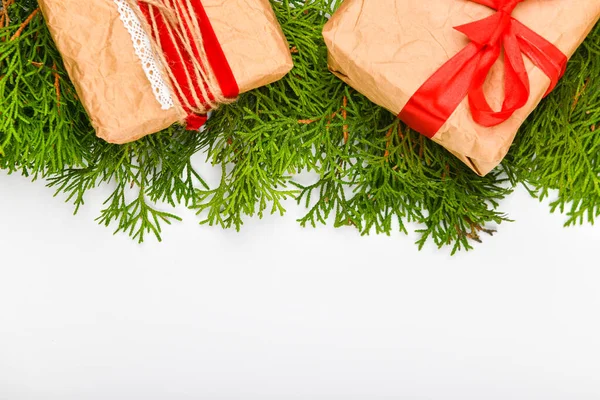 白い背景に紙で作ったギフト包装。緑の枝書く場所だ上からの眺め。手作りのシンプルなクリスマスギフト空白のトップビューの背景。ギフトボックスクリスマスツリー — ストック写真