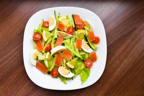 Beyaz tabakta sebze salatası. Yumurtalı taze salata, domates, ıspanak ve beyaz ahşap arka plan manzaralı avokado. Sağlıklı yemek.. — Stok fotoğraf