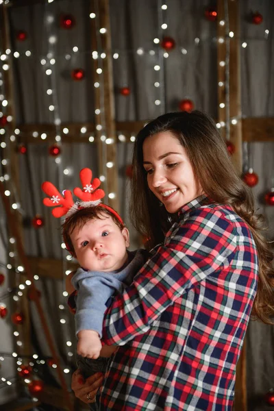 Noel 'de anneyle bebek. Mutlu aile annesi ve küçük oğlu Noel tatillerinde evde oynuyorlar. Yeni yıl tatili. Annenle birlikte Noel ağacıyla süslenmiş bir odada bebek. Po — Stok fotoğraf