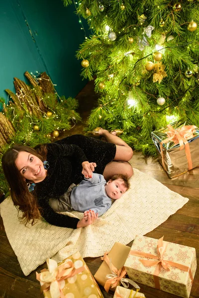 Baby mit Mutter an Weihnachten. glückliche Familienmutter und kleiner Sohn, die an den Weihnachtsfeiertagen zu Hause spielen. Neujahrsferien. Kleinkind mit Mama im festlich geschmückten Raum mit Weihnachtsbaum. po — Stockfoto