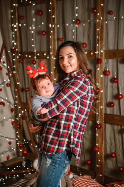 Christmas and mother concept. Christmas and people concept - mother and baby with gifts. On a Christmas background. warm christmas.