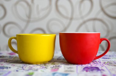 Kırmızı ve sarı kupa masanın üstünde duruyor..