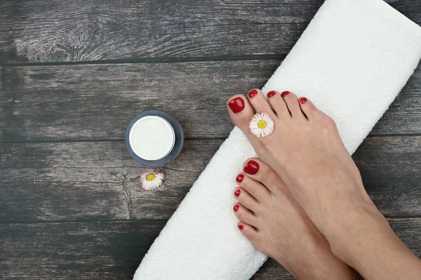 Spa and foot care concept. Women\'s legs with a white rolled towel. High quality photo