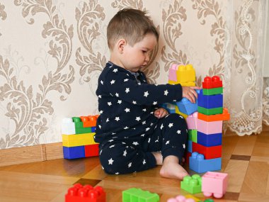 Bir çocuk çok renkli bir inşaatçıdan bir figür oluşturur. Yüksek kalite fotoğraf