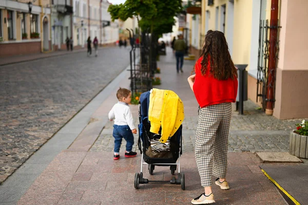 Eine junge Mutter geht mit einem Kind durch die Stadt — Stockfoto