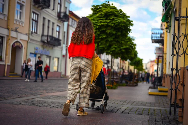 Молодая мать гуляет по городу с ребенком — стоковое фото
