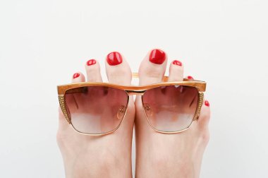 Plajda tatil kavramı. Ayaklar gözlüklü, beyaz arka planda, yakın plan. Yüksek kalite fotoğraf