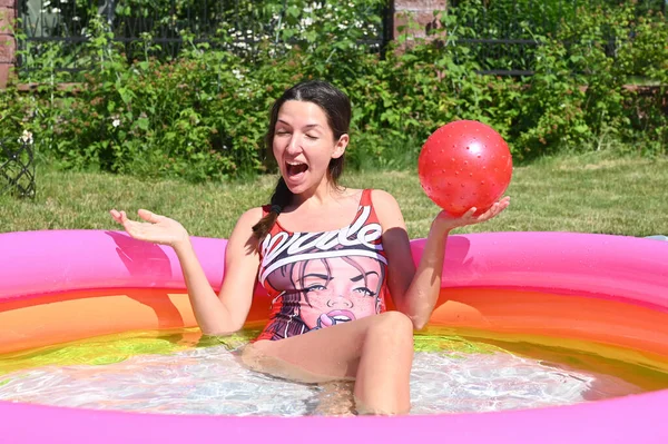 Girl escapes from the heat in the pool at home. High quality photo