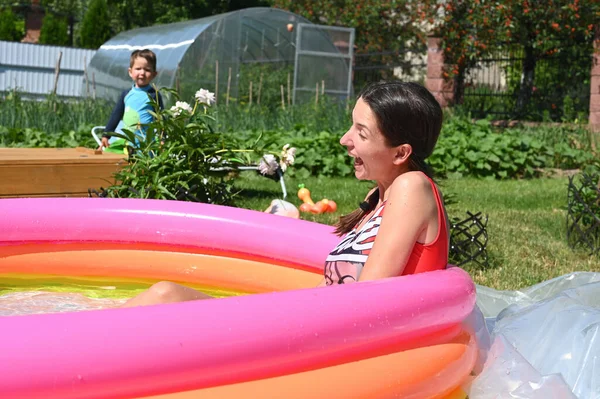 Girl and home inflatable pool — Stock Photo, Image