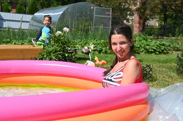 Girl sitting in an inflatable pool — Stock Photo, Image