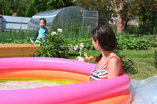 Mother and baby play in inflatable pool — Stock Photo, Image